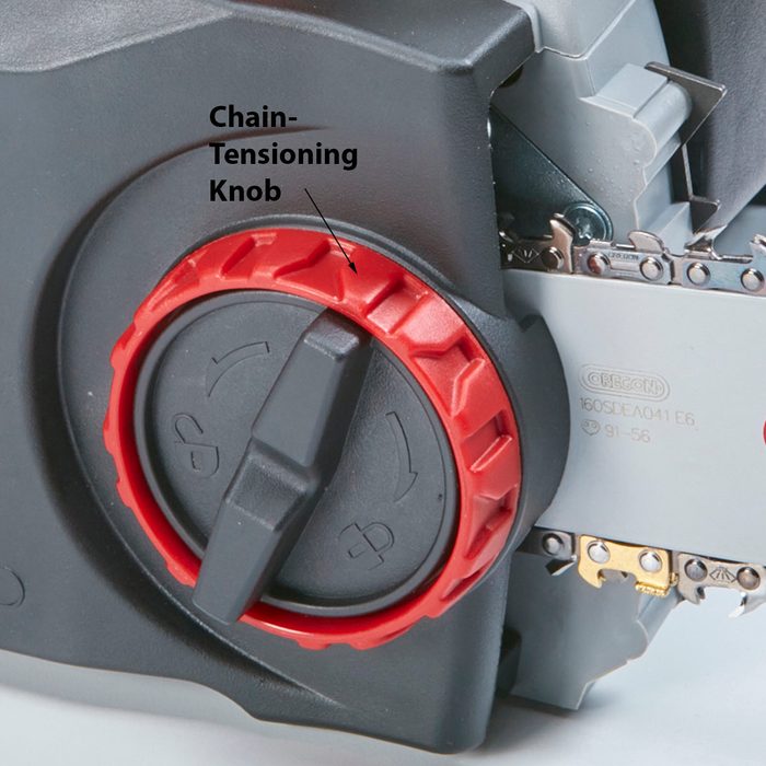 A red chain-tensioning knob adjusts the tension of a chainsaw's chain, set against a backdrop of metal and plastic components supporting the blade.