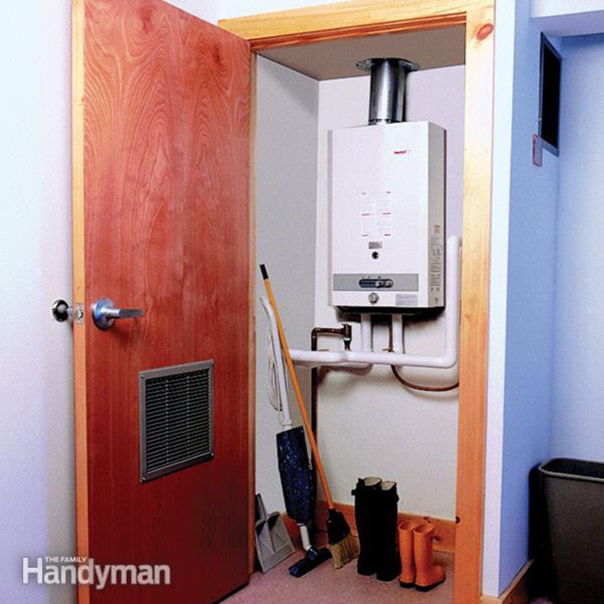 A water heater stands in a small nook, with cleaning tools and boots nearby, and a wooden door partially open at the entrance.