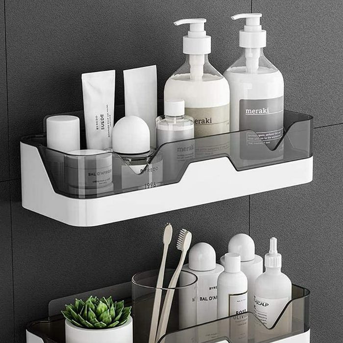 A wall-mounted shelf holds various skincare products and toiletries, featuring bottles, tubes, and accessories, in a modern, organized bathroom setting.