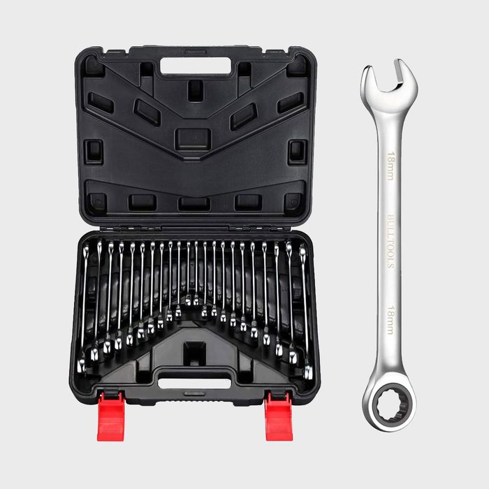 A silver wrench lies beside an open black storage case filled with various shiny, metal socket wrenches organized neatly inside.