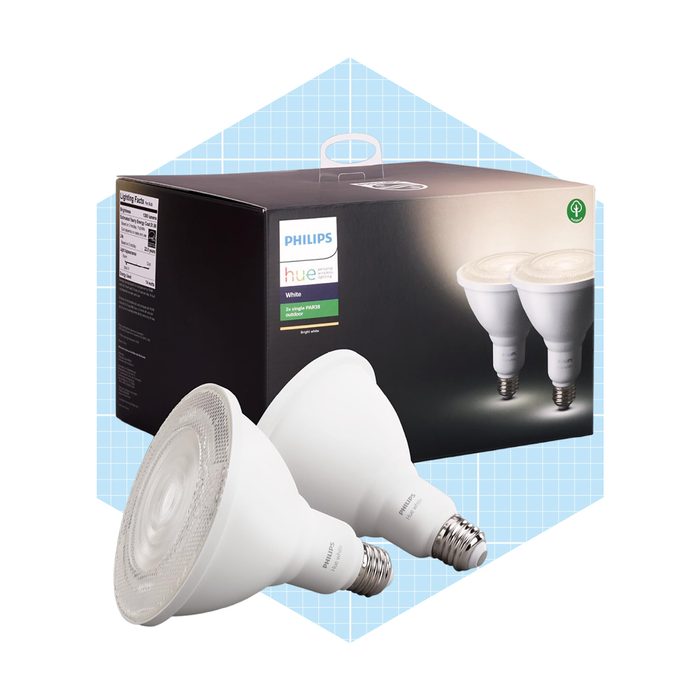 Two white LED light bulbs are positioned beside their packaging, showcasing a modern and sleek design against a light blue grid background.