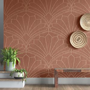 A patterned wall with a warm brown color features intricate designs. A green potted plant and a wooden bench are positioned in front, enhancing the interior decor.