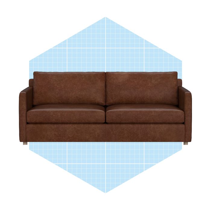 A brown leather sofa sits upright, displaying its two spacious cushions, against a light blue geometric background, creating a modern, minimalist look.