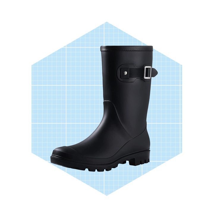 A black rubber boot stands upright, featuring a buckle on the side, set against a light blue grid background.