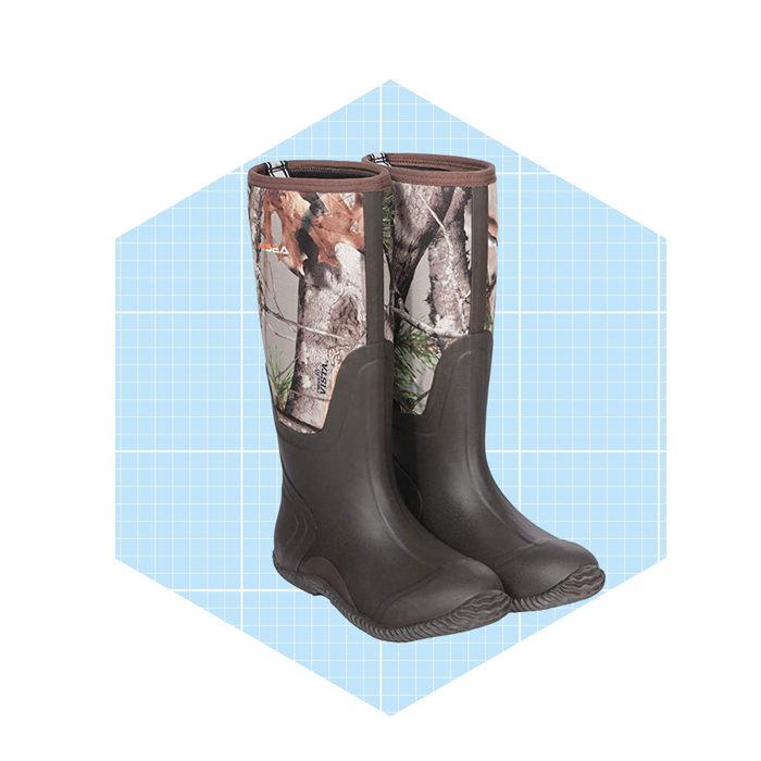 A pair of camouflage-patterned rubber boots stands upright against a light blue grid background, designed for outdoor activities like hunting or fishing.