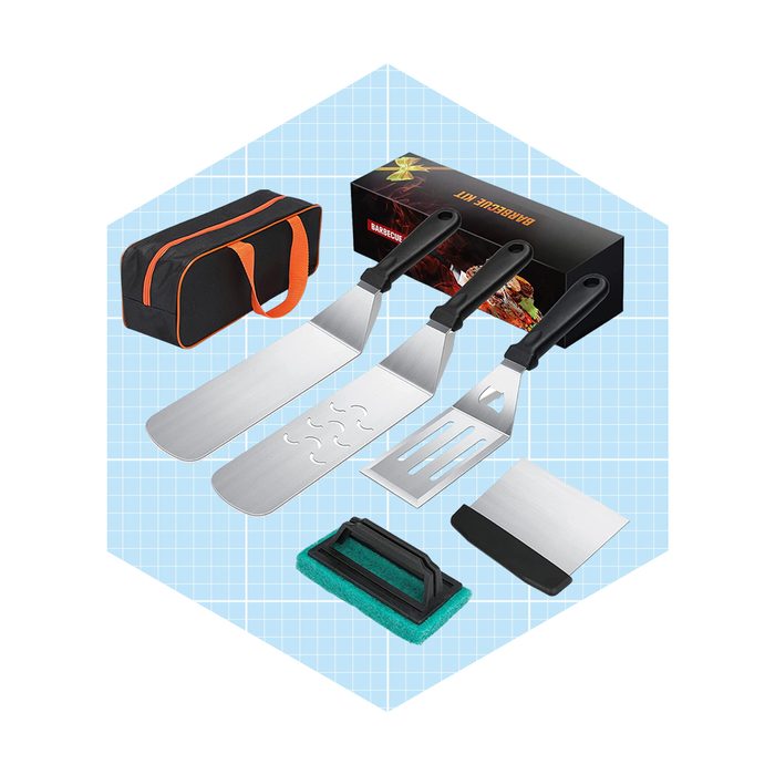 Three stainless steel grilling tools and a cleaning sponge are arranged beside a storage bag, set against a light blue grid background.