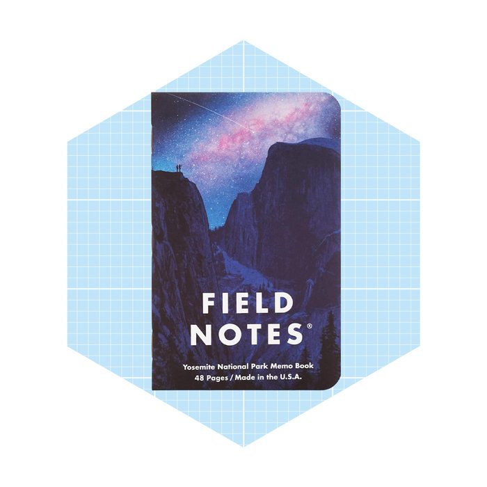 A memo book with a night sky illustration showcases silhouettes of two figures on a cliff, surrounded by mountains and stars, labeled 