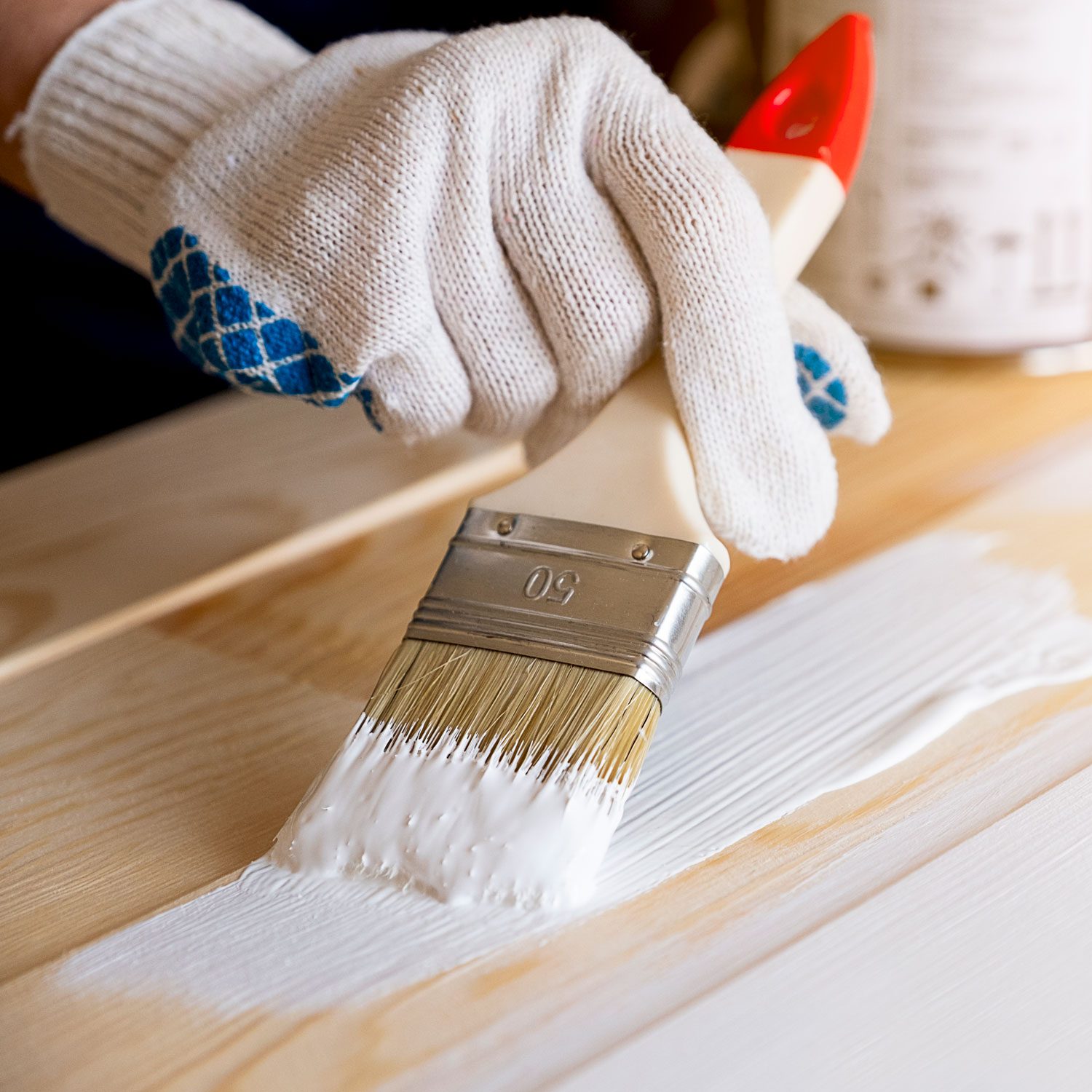 Brush With White Paint In The Hands Of Someone In Protective Gloves