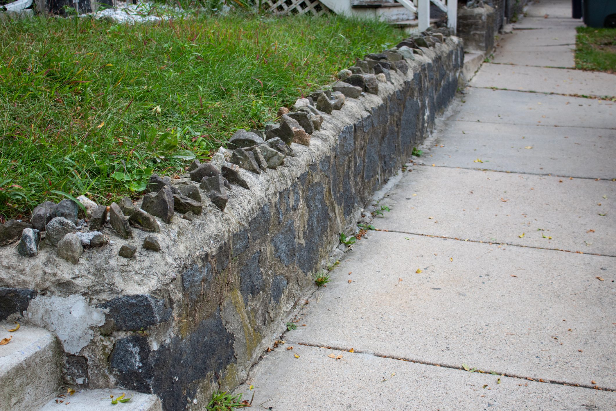 Stone topped retaining wall beside a sidewalk and stairs