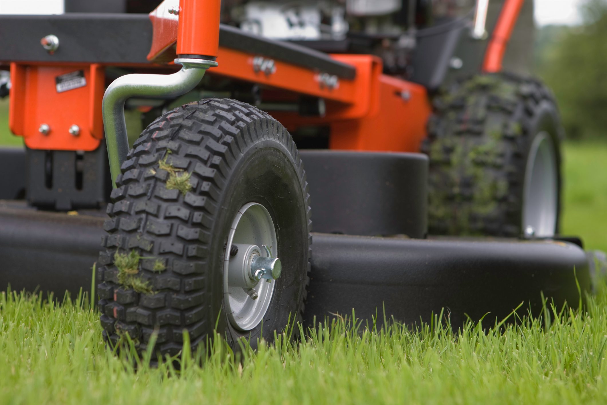 Close-up of the wheels and base of a working lawn mower