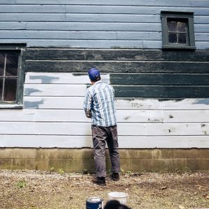 man painting exterior of house